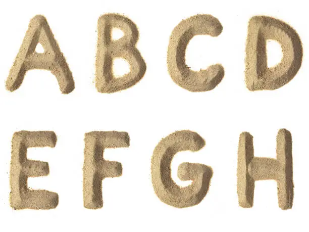 A-B-C-D-E-F-G-H alphabet sand letters.