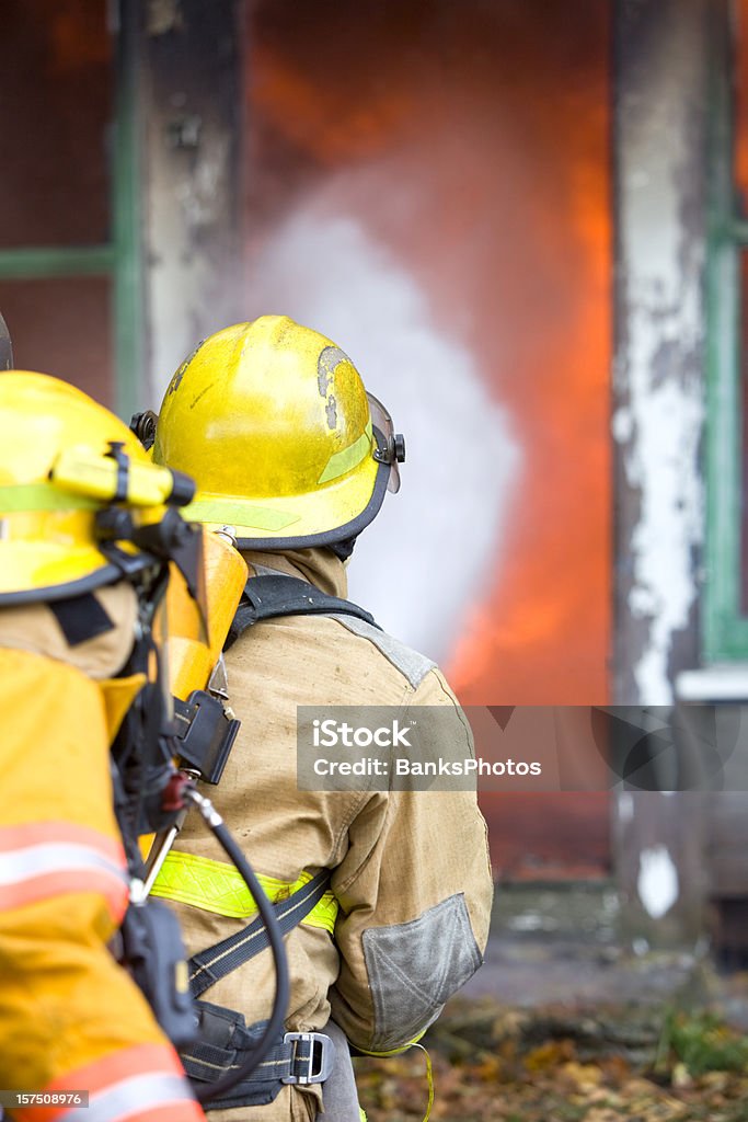 Bomberos haciendo una casa de incendios - Foto de stock de Bombero libre de derechos