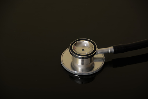 Medical stethoscope isolated on a black background.
