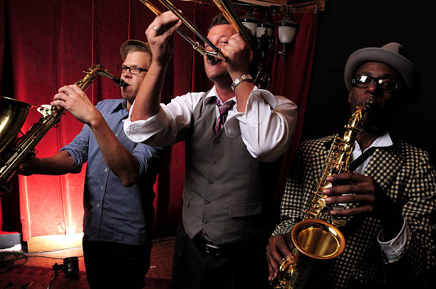 istock Three jazz musicians playing music with red curtain in back 157509496