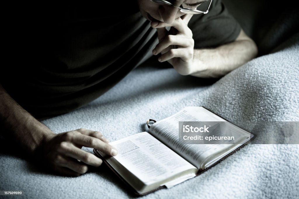 Reading the Bible A young man reading his bible, alone in his room.  20-29 Years Stock Photo