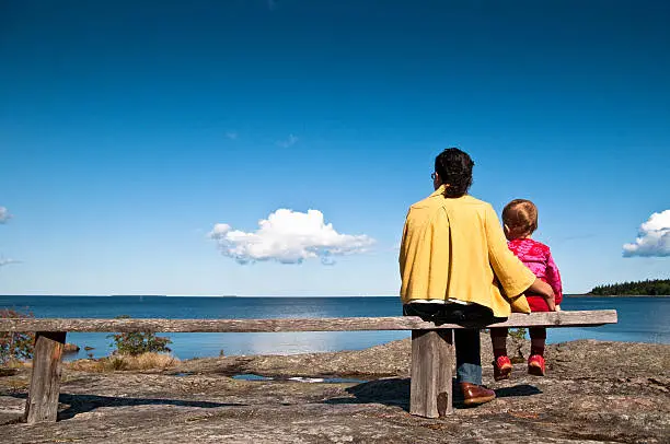 Mother and doughter looking at the clouds passing by over the Baltic Sea from the coast of Sweden.