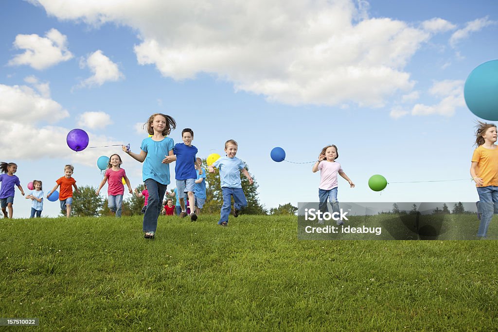 Gruppo di bambini felici in esecuzione con palloncini - Foto stock royalty-free di Bambino