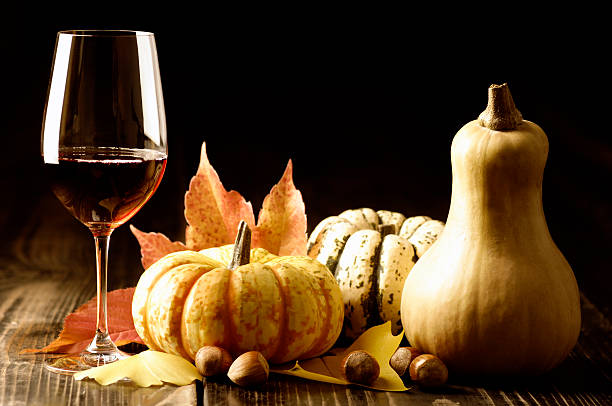 Autumn decor including pumpkins, gourds, wine and leaves stock photo