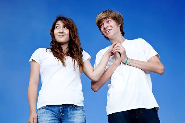 Photo of teenage couple being silly, play acting like grown-ups