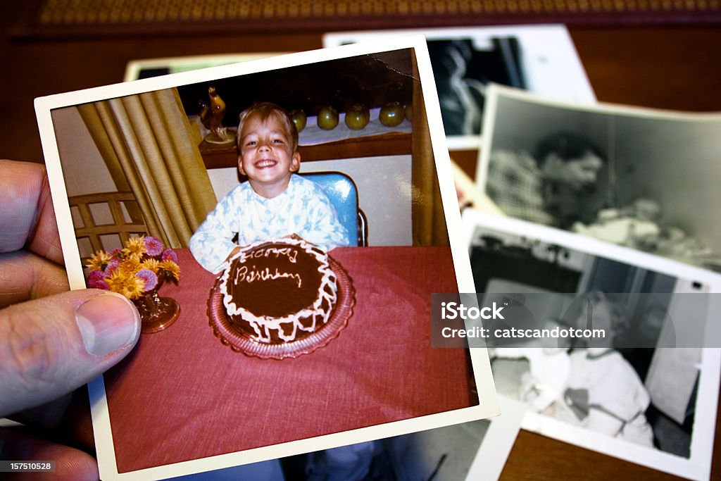 Hand holds Vintage photograph of child and birthday cake  Nostalgia Stock Photo