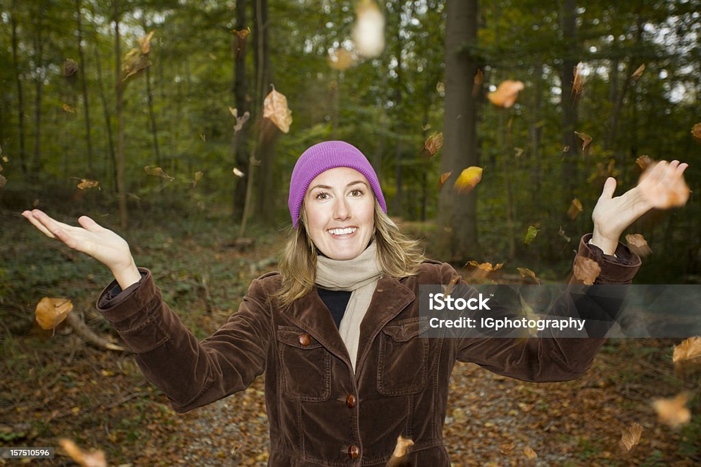 Jovem mulher com outono folhas na floresta, balançando no vento - Foto de stock de Adulto royalty-free