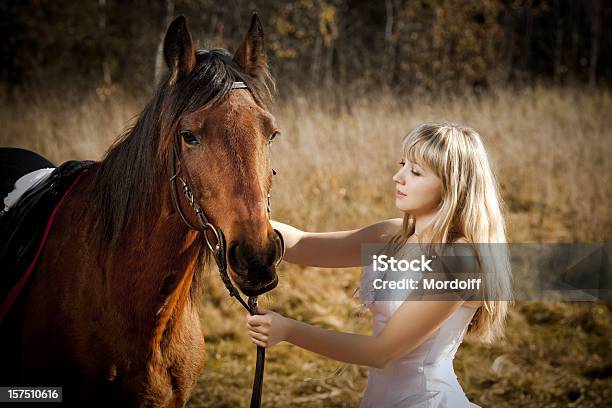 Młoda Kobieta W Białą Sukienkę Caressing Horse - zdjęcia stockowe i więcej obrazów Adolescencja - Adolescencja, Biały, Blond włosy