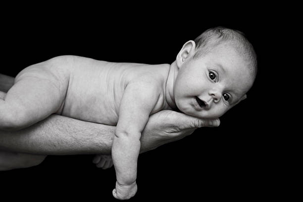 Newborn baby holds momma's finger.