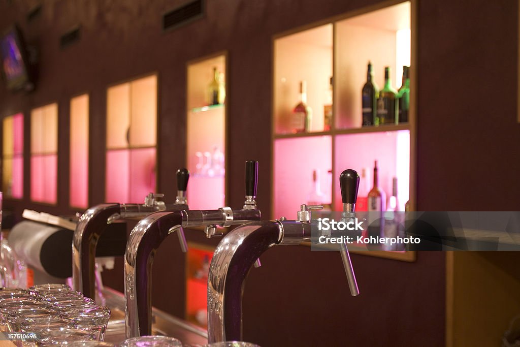 Machos de roscar de una cerveza en el bar - Foto de stock de Anochecer libre de derechos