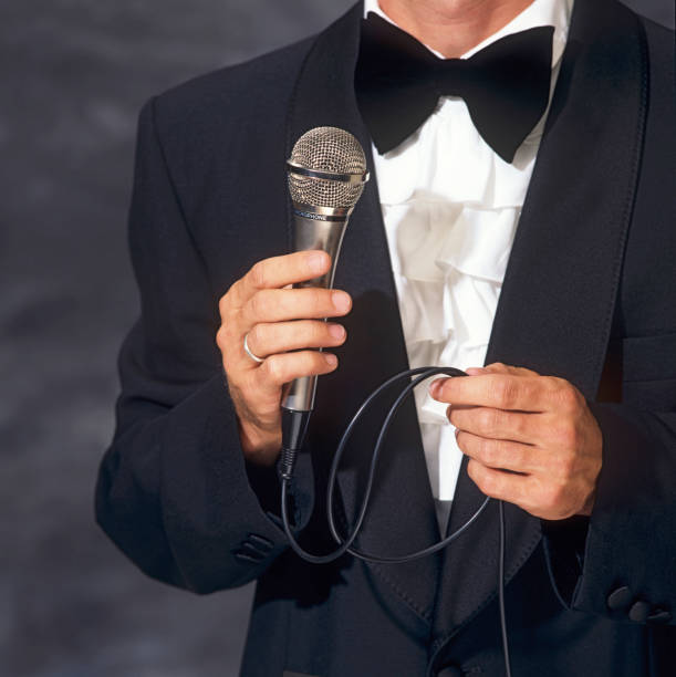 istock Conferencier in elegant suit holding the microphone 157510936