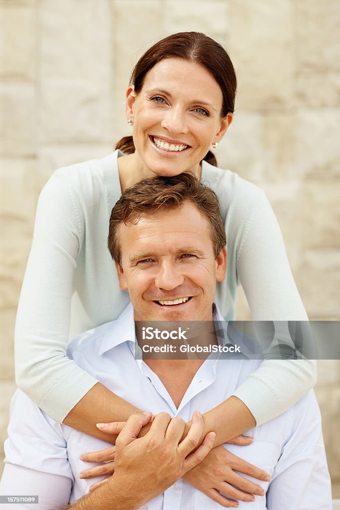 Felice moglie abbracciare il marito da dietro - Foto stock royalty-free di Abbracciare una persona