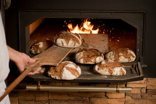 Fresh yummy delicious and appetizing breads being baked inside an oven in a bakery kitchen