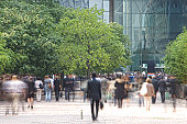 Business people walking in a financial district, blurred motion