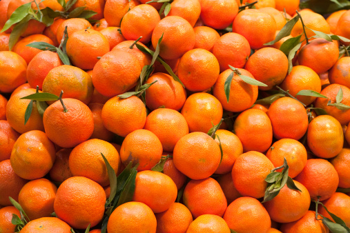 Sliced mandarin oranges on white background.\nJapanese fruit.