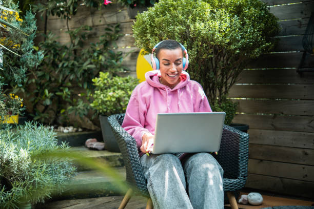 istock Young woman freelancing from her garden 1575119994
