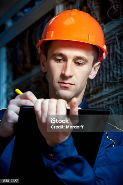 Construction Engineer In Automatic Switching Center Taking Notes Stock Photo - Download Image Now