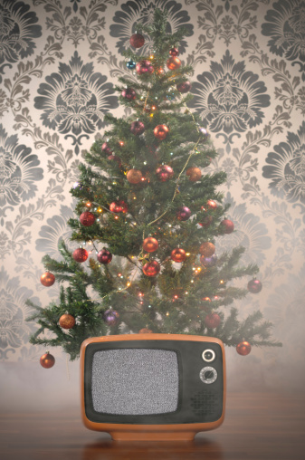Old BW TV. is in front of a Christmas Tree and foggy atmosphere to create dreamy effect.