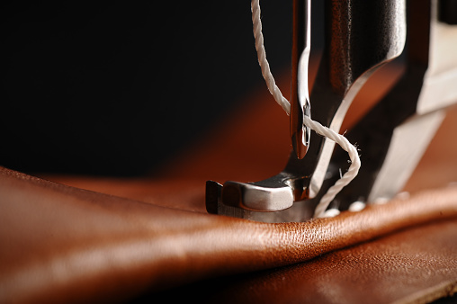 Macro, close-up of needle penetrating leather