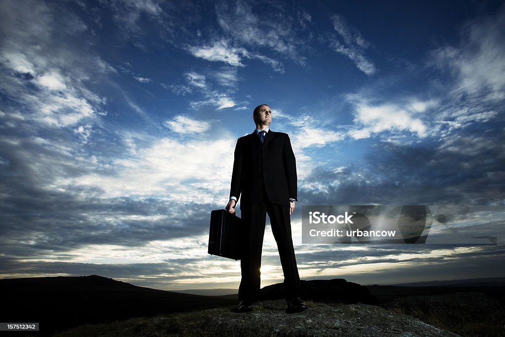 Businessman looking to the distance Businessman on a rock looking to the horizon Moor Stock Photo