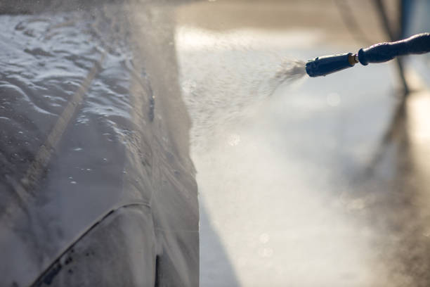 istock Worker washing car at self-service car wash 1575124364