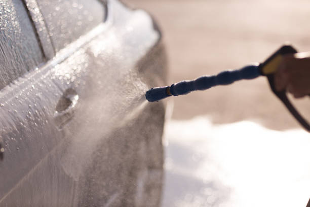 istock Worker washing car at self-service car wash 1575124368