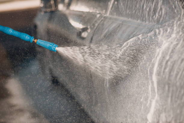 istock Worker washing car at self-service car wash 1575124379