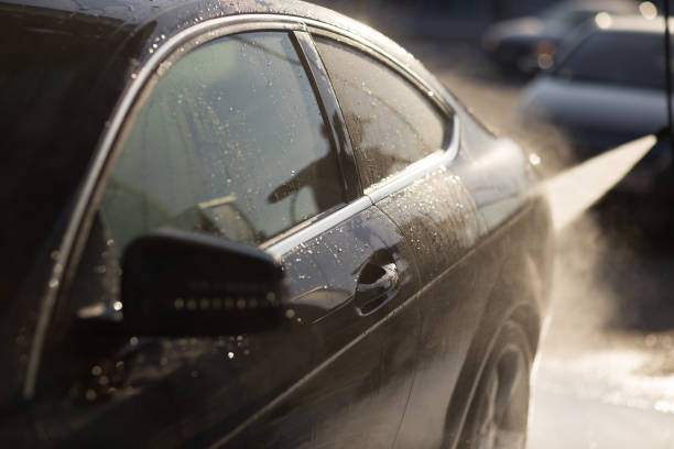 istock Worker washing car at self-service car wash 1575124891