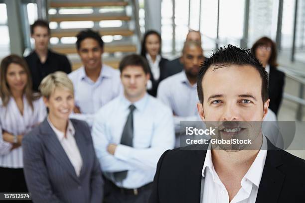 Foto de Empresário Sorrindo Com Colegas No Fundo e mais fotos de stock de 20 Anos - 20 Anos, 20-24 Anos, Adulto