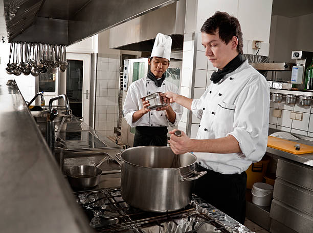 chefe de cozinha e pelo formando - chef trainee cooking teenager imagens e fotografias de stock