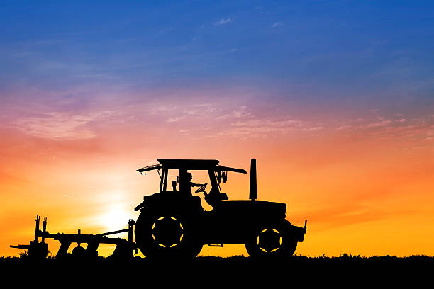 istock Dawn over tractor plowing a field 157512861