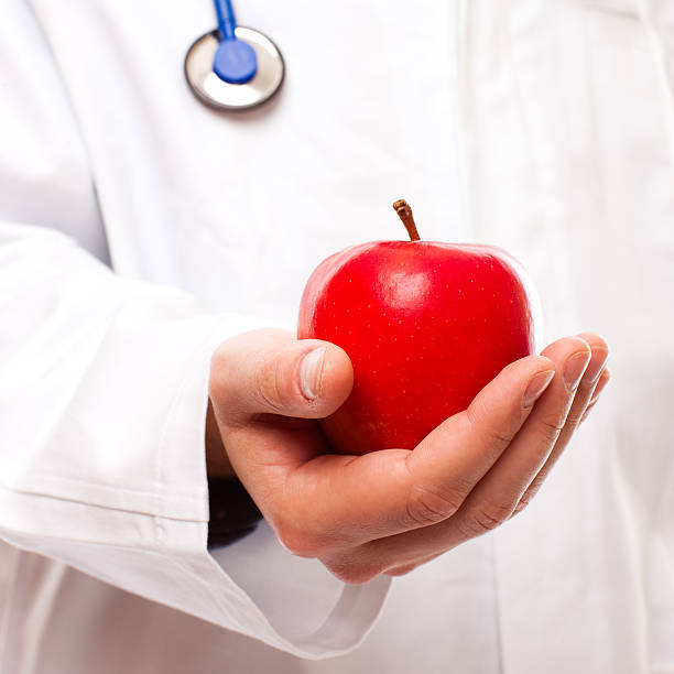 istock Doctor Holding Out Red Apple, Studio Shot 157512960
