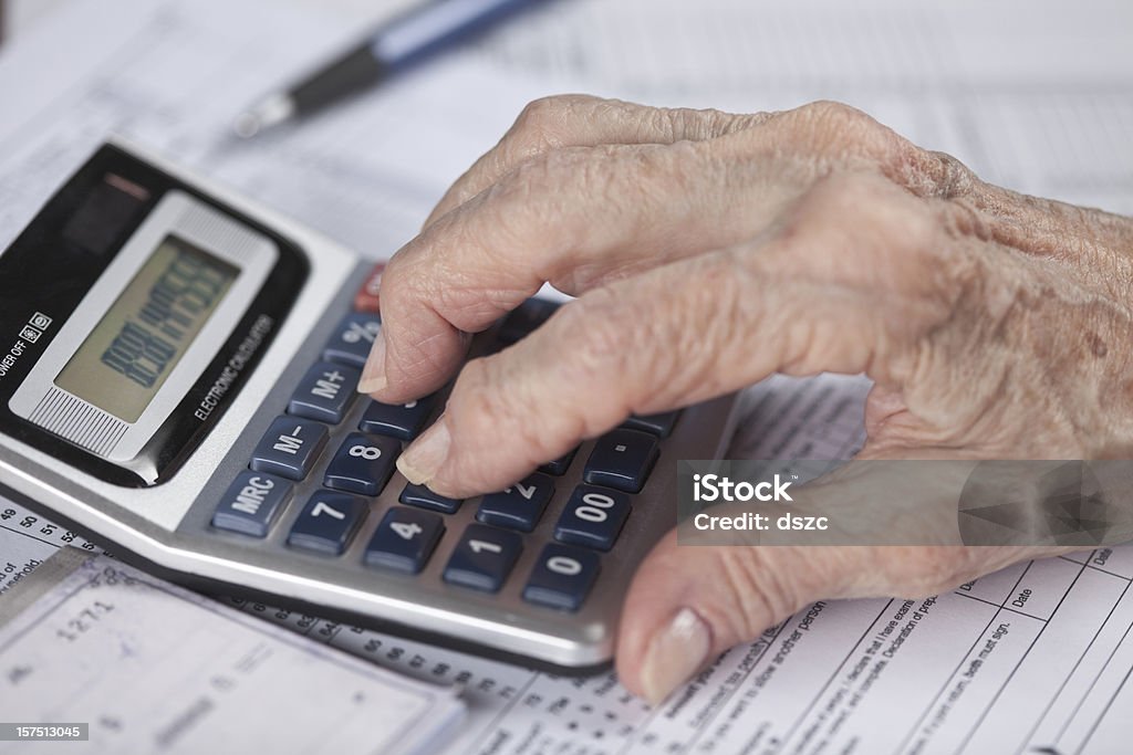 Donna anziana mano facendo finanziario di lavoro di Calcolatrice - Foto stock royalty-free di Calcolatrice