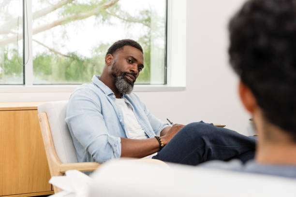 istock Counselor looks appraisingly at his unrecognizable male client 1575141996