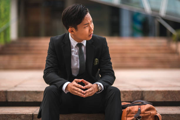 istock Worried Asian Man with a Suit Looking Away 1575147917