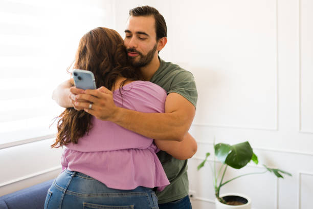 istock Handsome man texting and cheating on his girlfriend 1575169759