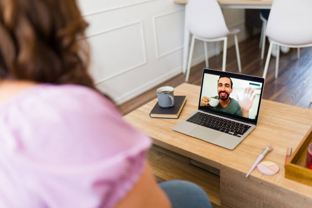 istock Rear view of a couple seen from behind talking on a video call 1575173402