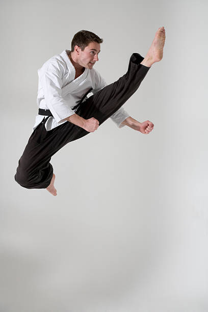 Black Red Belt TaeKwonDo Karate male athlete man show traditional Fighting poses punch on black background