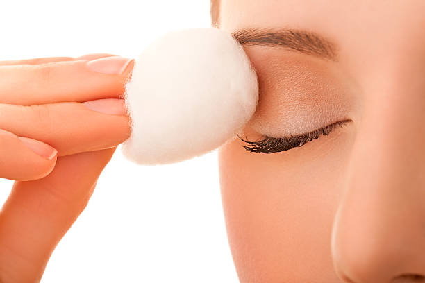 Female using cotton ball to remove eye make-up stock photo