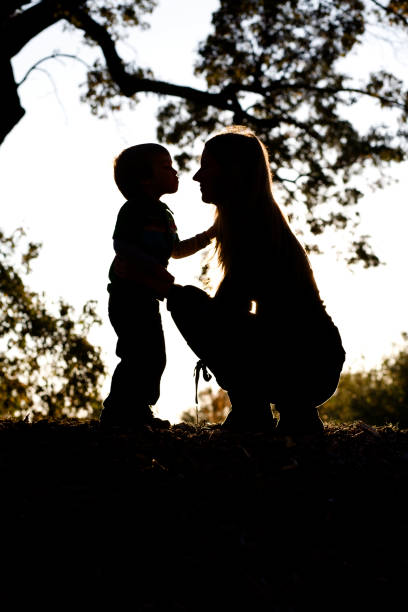 silhueta de mãe e filho - silhouette kissing park sunset imagens e fotografias de stock