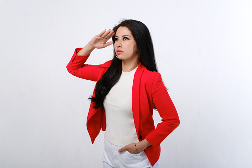 Asian female with red and white dress giving a salute to celebrate Indonesian independence day on 17th of August isolated on white background