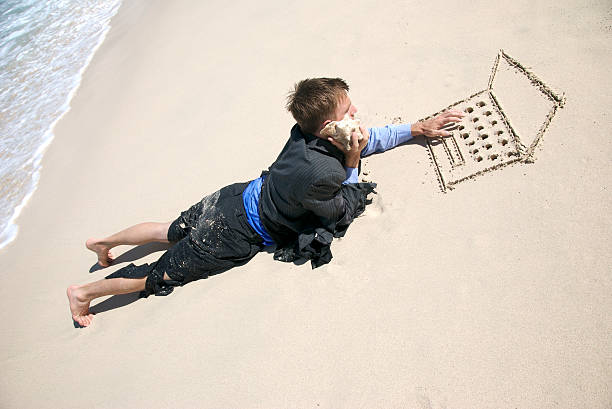 multitâche castaway homme d'affaires travaillant sur la plage - computer humor stranded business photos et images de collection