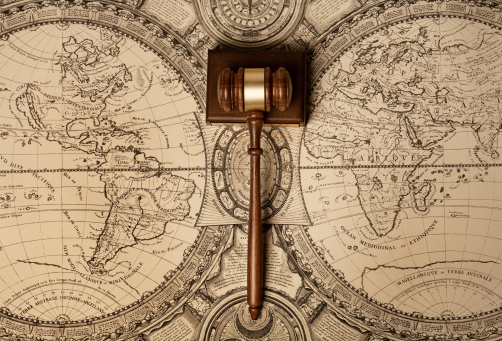 Gavel of justice on old world map