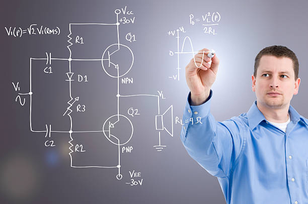 An electronics engineer drawing a circuit on glass wall stock photo