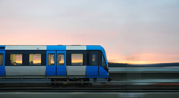 istock Subway train in profile crossing bridge at sunset 157523349