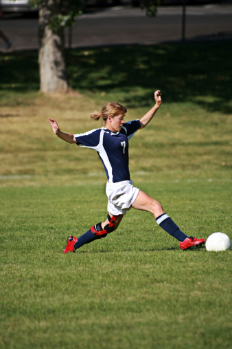 Soccer player strietches to control ball