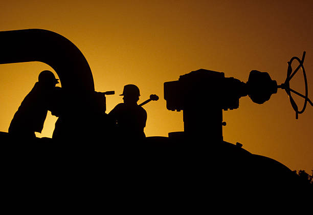 Silhouette of workers working on site at sunset stock photo