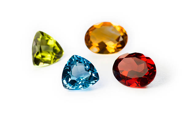 Precious Gemstones Garnet Imperial Topaz Ruby and Sapphire Closeup of precious (from top left clockwise:Garnet,Imperial Topaz,Ruby and Sapphire) gemstones on white background garnet stock pictures, royalty-free photos & images