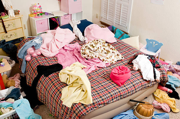 Messy bedroom with clothing thrown in disarray stock photo