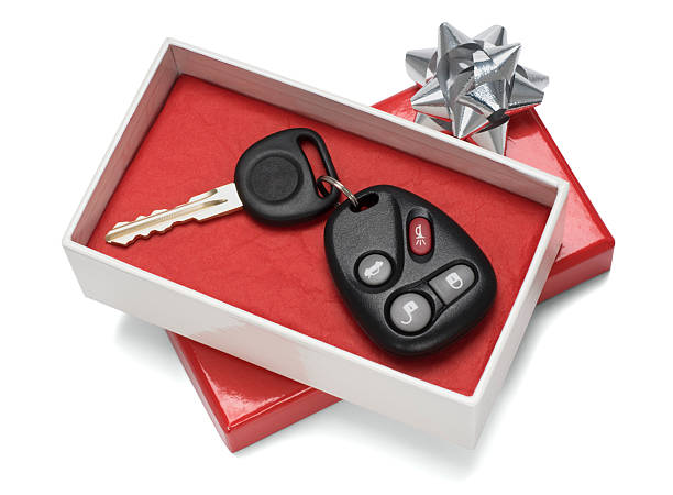 Vehicle keys in white and red gift box with silver bow Gift box with car keys inside. Isolated on white with clipping path included. key package stock pictures, royalty-free photos & images